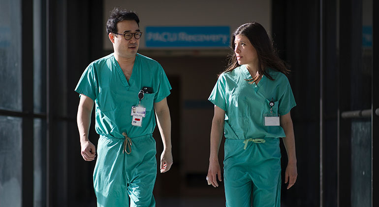 Image of two surgeons walking down the hall