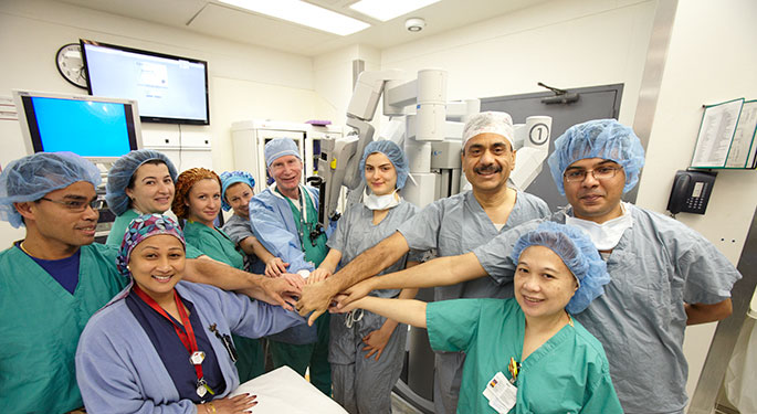 Operating room shot with everyone’s hands in the middle