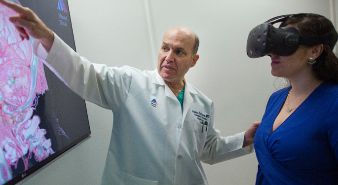 image of Dr. Bederson with staff member using goggles to view brain scan on screen