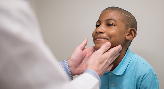 Doctor examining boy’s throat