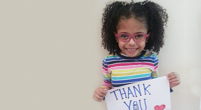 Little girl holding sign saying thank you