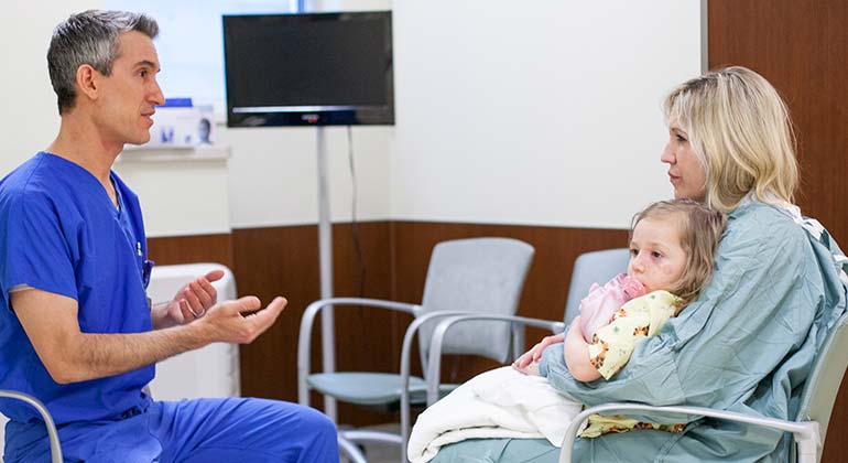 Dr. Gregory Levitin, discussing with female child patient and mother about vascular birthmark treatments