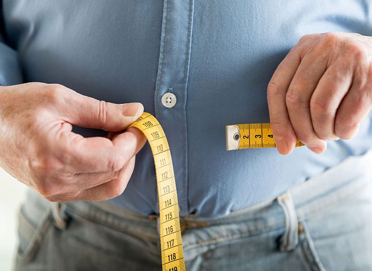 Photo of person using measuring tape for their waist