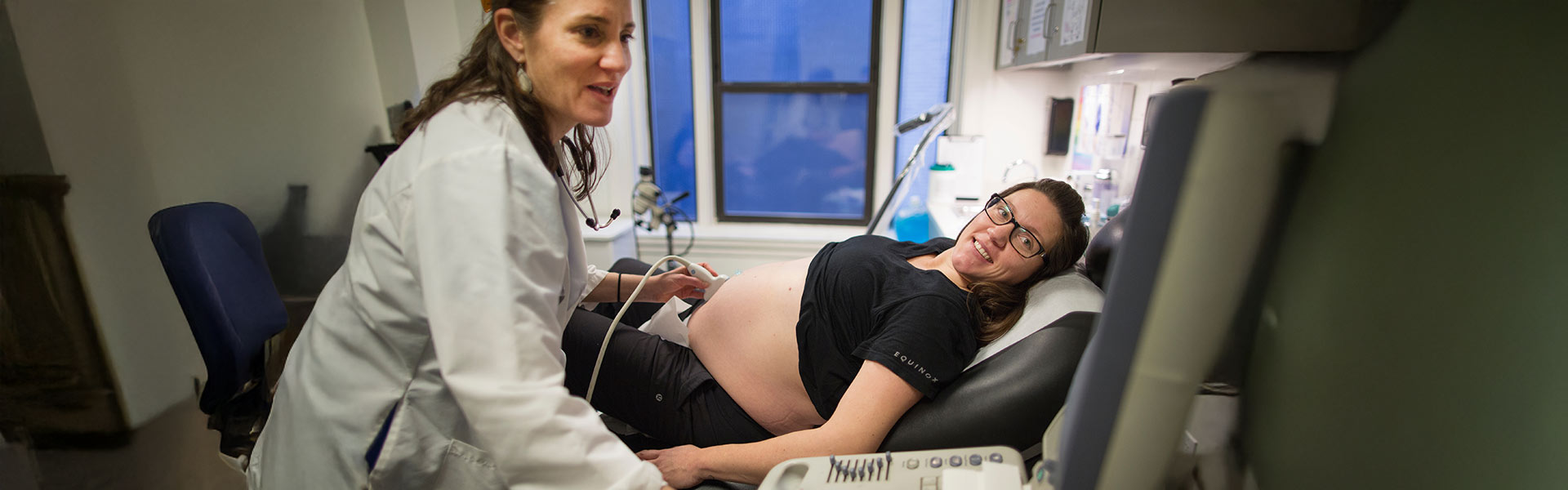 doctor performing a sonogram on pegnant patitent