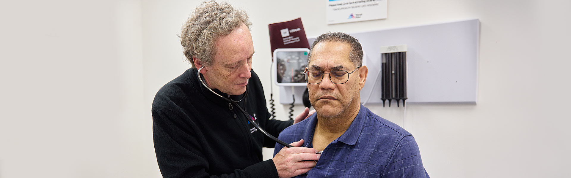 doctor using stethoscope on patient