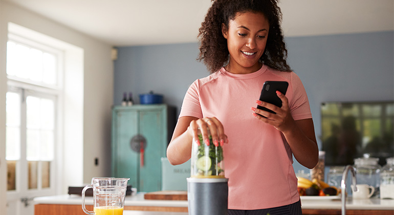 woman preparing food looking at phone